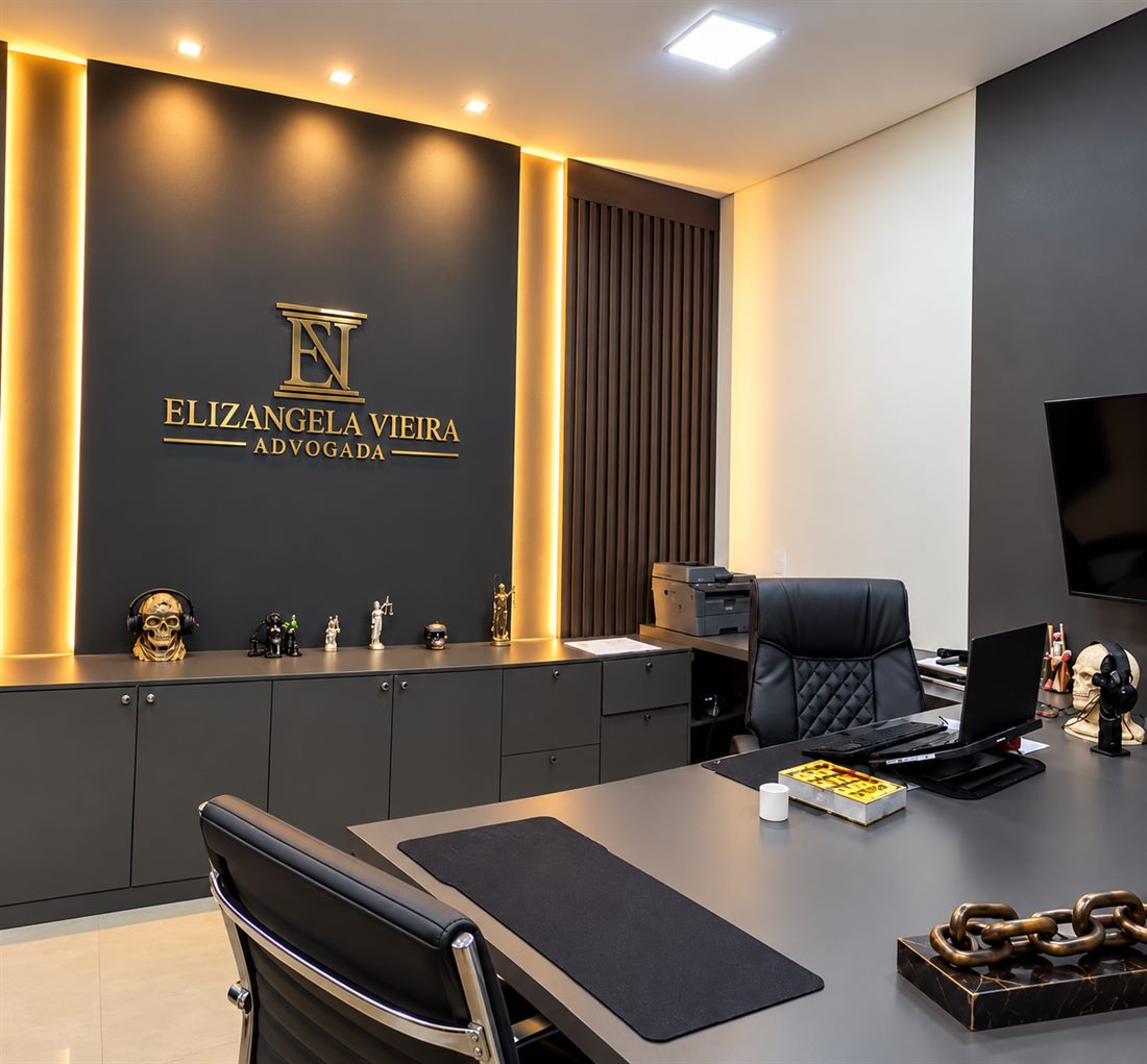 Sala do escritório com o logo Elizangela Vieira Advogada em dourado na parede